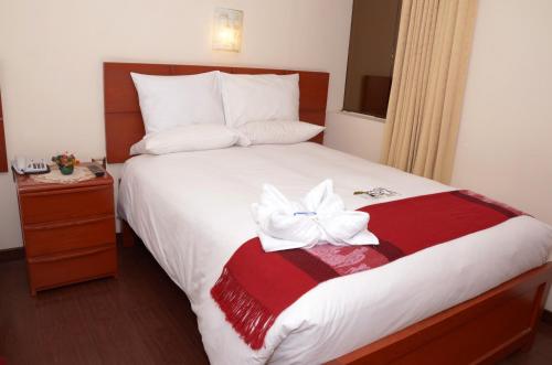 a hotel room with a bed with a white flower on it at Golden Inca Hotel in Cusco