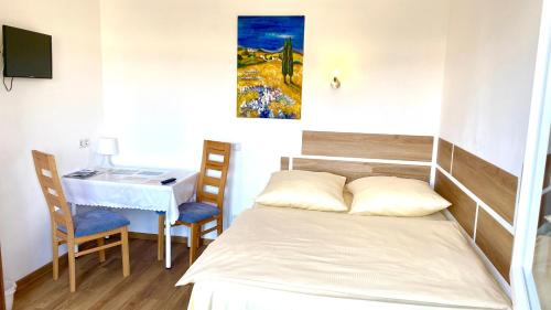 a bedroom with a bed and a desk and a table at i-Motel in Obertshausen