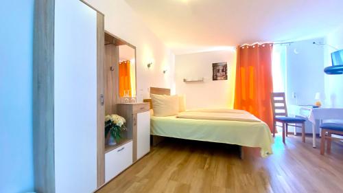 a small bedroom with a bed and a table at i-Motel in Obertshausen