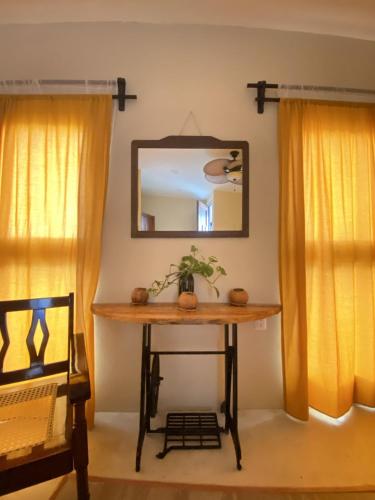 a table in a room with a mirror and a chair at Aj Mun, Hotel Real Maya 3 in Valladolid