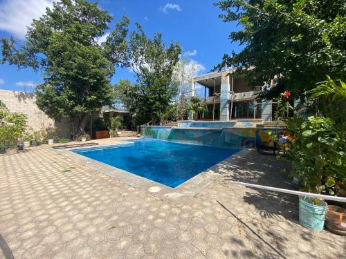 - une piscine en face d'une maison dans l'établissement Aj Mun, Hotel Real Maya 3, à Valladolid