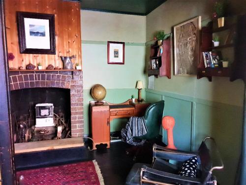 a living room with a fireplace and a chair at UNIQUE 1920's Historic Retreat! Pet Friendly! in Springwood