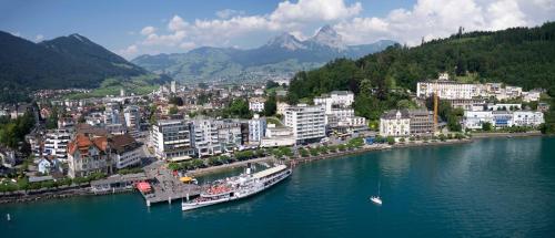 a city on a river with a boat in the water at Ferienwohnung Seesicht in Brunnen
