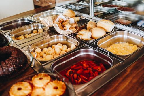 a buffet filled with different types of food in trays at Hotel Fita Azul in Ilhabela