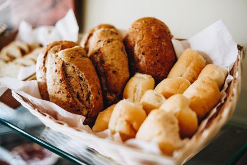 a basket of different types of bread on a glass shelf at Hotel Fita Azul in Ilhabela