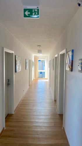a hallway of an empty room with a sign on the ceiling at i-Motel in Obertshausen