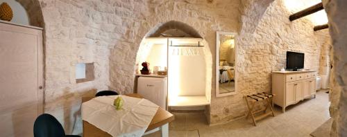 eine Küche und ein Esszimmer mit einem Tisch und einem Spiegel in der Unterkunft Trullo Monte Santo 50 in Alberobello