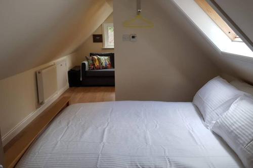 1 dormitorio con 1 cama, ventana y sofá en Riverside Lodge Pied a Terre, en Fordingbridge