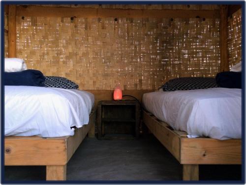 a bedroom with two beds and a candle on a table at Camp - Santos Camp With All The Comforts in Todos Santos