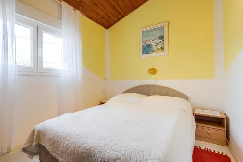 a bedroom with a white bed and a window at Villa Fontana in Starigrad-Paklenica