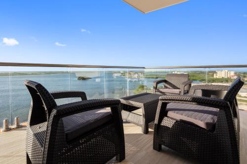a balcony with chairs and tables and a view of the water at Sunset Caribe Belize in San Pedro
