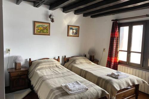 a bedroom with two beds and a window in it at Guest House "Villa YANA" in Golyama Zhelyazna