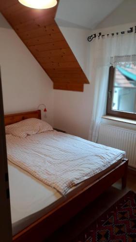 Bett in einem Schlafzimmer mit Holzdecke in der Unterkunft Ferienhaus und Apartment Idolsberg in Idolsberg
