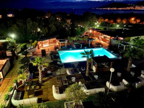 an aerial view of a swimming pool at night at Bella Vista Hôtel, Suites & Maisons in Porticcio