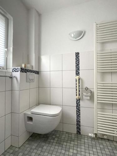 a white bathroom with a toilet and a shower at Villa Lotte in Lichtenfels