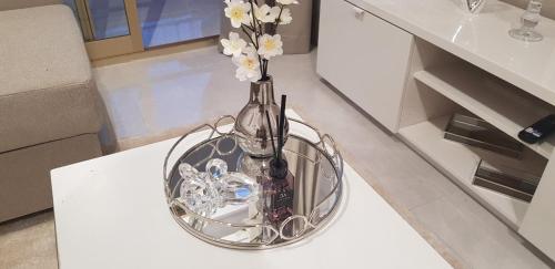 een vaas met bloemen erin zittend op een tafel bij Elegante apartamento en Playa de Gandía in Playa de Gandia