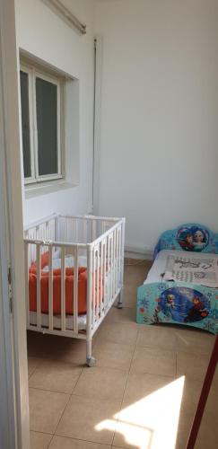 żłobek z łóżeczkiem dziecięcym i łóżkiem w pokoju w obiekcie Family house bahai gardens w mieście Hajfa