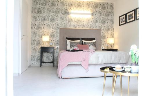 um quarto com uma cama com um cobertor rosa em Il Melograno em Prato
