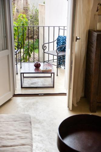 an open door to a balcony with a table and a chair at La Casa Dell'Arancio in Favignana