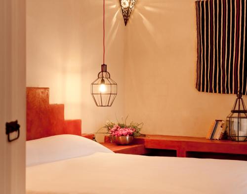 a bedroom with a bed and a pendant light at La Casa Dell'Arancio in Favignana