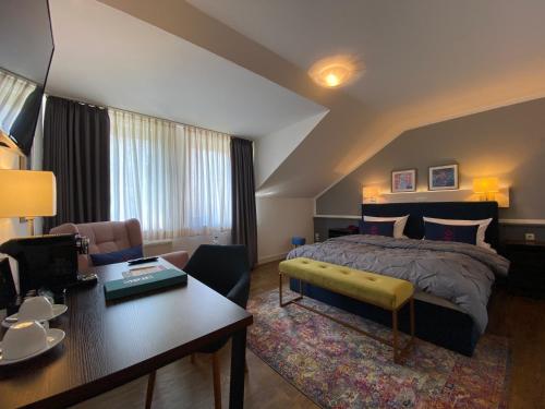 a bedroom with a bed and a desk in a room at Hafen Hotel Schützenhof in Burg auf Fehmarn