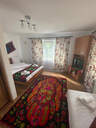 a bedroom with two beds and a rug on the floor at Floare de Maramures 1 in Vadu Izei