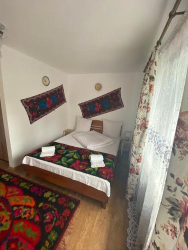 a small bedroom with two beds and curtains at Floare de Maramures 1 in Vadu Izei