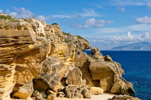 a rocky cliff with the ocean in the background at La Casa Dell'Arancio in Favignana