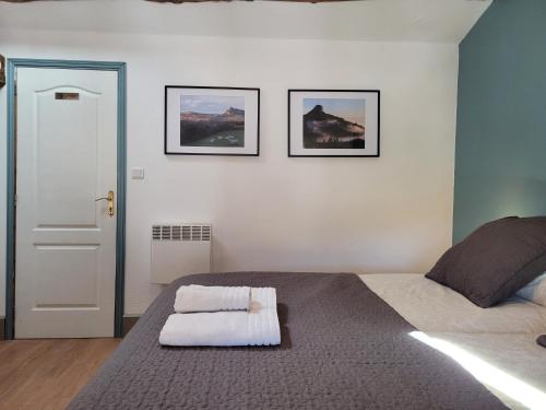a bedroom with a bed with two pictures on the wall at Les Portails Bleus in Azé
