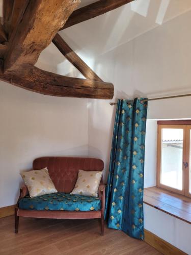 a couch in a room with a window at Les Portails Bleus in Azé