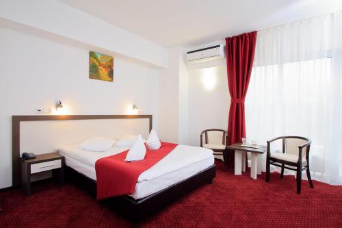 Habitación de hotel con cama y alfombra roja en Hotel President en Băile Olăneşti