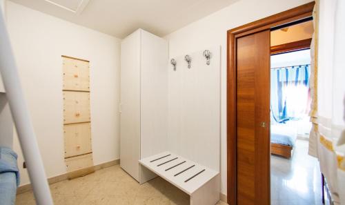 una habitación con un banco blanco junto a una puerta en Dimora Laguna en Pellestrina