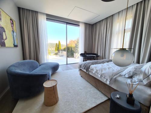 a bedroom with a bed and a chair and a window at Suiten-Aparthotel AENEA in Reifnitz