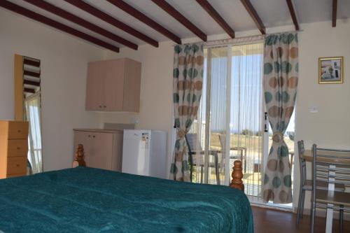 ein Schlafzimmer mit einem grünen Bett und einem Balkon in der Unterkunft MERSINERA PARADISE GARDEN STARS HOUSE in Larnaka
