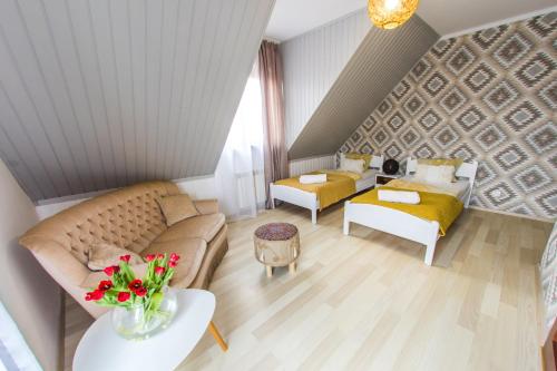 a living room with a couch and a table at Gościniec Pod Lipą in Mikołajki