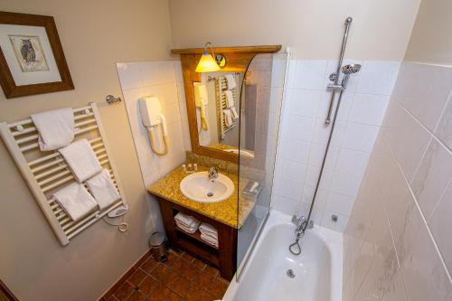 een badkamer met een bad, een wastafel en een douche bij Arc 1950 - Charmant appartement 2-4 personnes dans résidence hôtelière in Bourg-Saint-Maurice