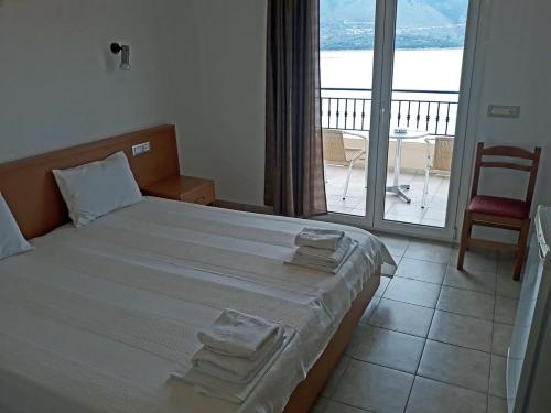 a bedroom with a large bed with towels on it at Plataria Palace in Plataria