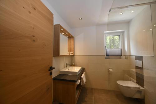 La salle de bains est pourvue d'un lavabo, de toilettes et d'une fenêtre. dans l'établissement Lechtal-Pur-Aparts, à Holzgau