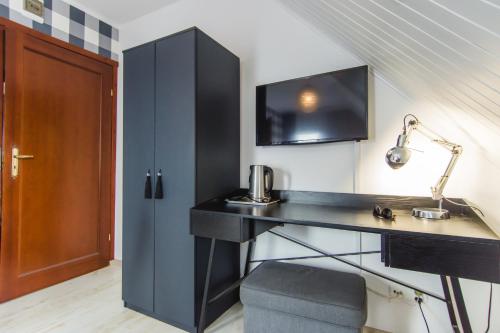 a room with a desk with a lamp and a cabinet at Gościniec Pod Lipą in Mikołajki
