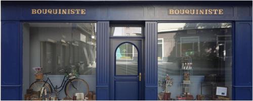 une vitrine bleue avec un vélo garé devant. dans l'établissement Le Bouquiniste, atypique, cosy, fibre, BedinShop, à Romans-sur-Isère