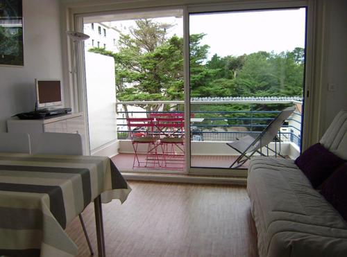 d'un salon avec un canapé et une vue sur un balcon. dans l'établissement STUDIO + La Baule 20m de la mer, à La Baule