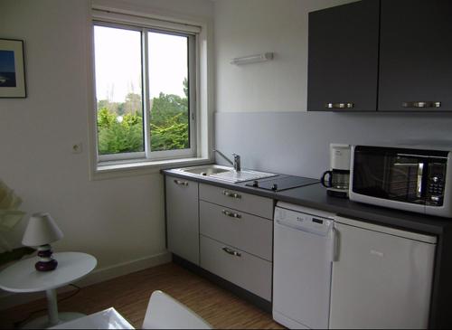 une cuisine avec un évier et un micro-ondes dans l'établissement STUDIO + La Baule 20m de la mer, à La Baule