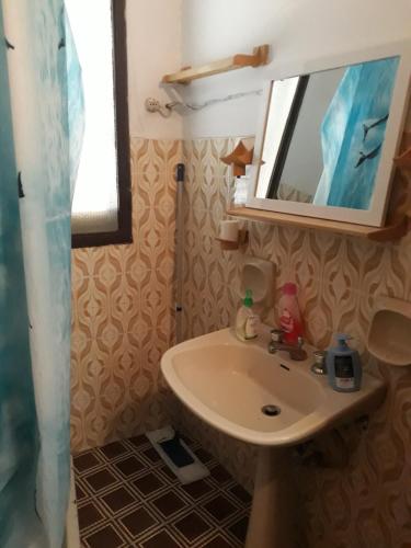 y baño con lavabo y espejo. en Casetta in centro en Soveria Simeri