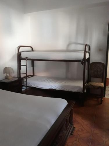 a room with two bunk beds and a chair at Casetta in centro in Soveria Simeri