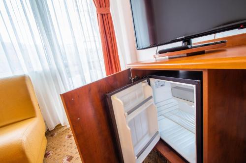 a small refrigerator with its door open in a room at Hotel President in Băile Olăneşti