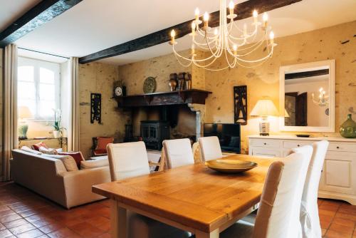 une salle à manger avec une table en bois et des chaises blanches dans l'établissement B&B Eth Béryè Petit, à Beaucens