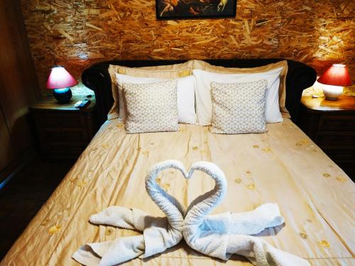 ein Bett mit zwei Handtüchern in Herzform in der Unterkunft Superior Apartment in Korinthos