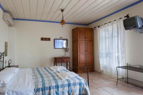 a bedroom with a bed and a tv on the wall at Chiliadromia Studios in Alonnisos Old Town
