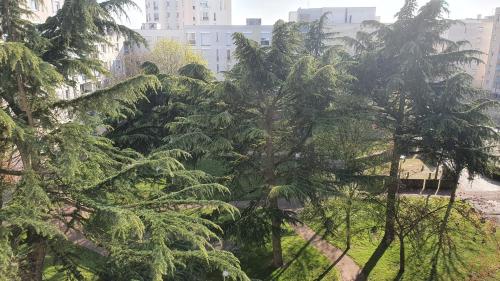 a group of trees in a city with buildings at Dans grand appart de 113m2 proche Paris in Creil