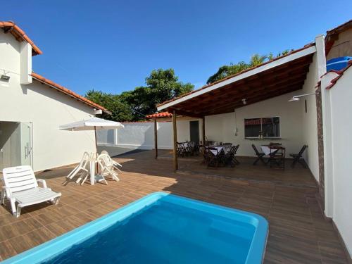 a house with a swimming pool and a patio at Pousada Nova Estrela da Canastra in Delfinópolis